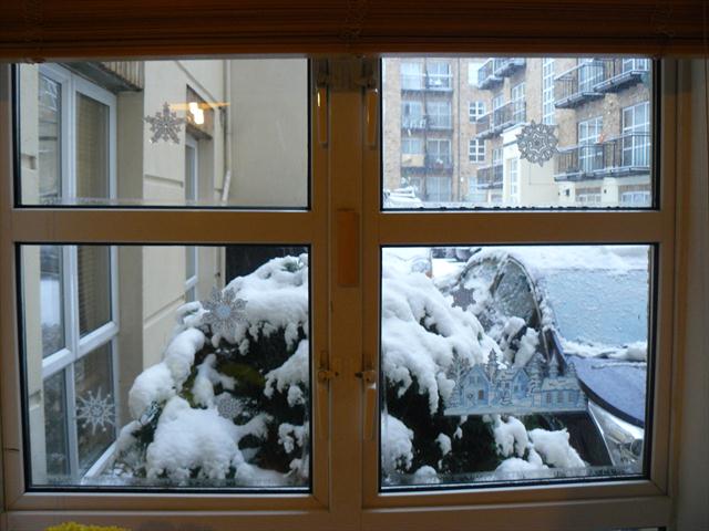 Zimní okno s vločkami na okně a zasněženou chaloupkou (jen pro jedince s výborným zrakem)